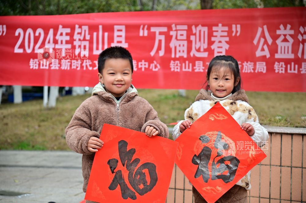 2023年1月26日，在江西省上饶市铅山县河口镇城东社区信江龙庭小区，书法爱好者正在挥毫泼墨，为居民书写心仪的春联和福字。